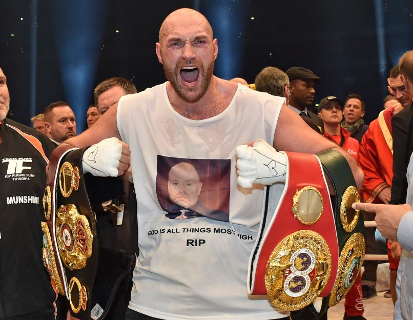 Tyson Fury holding multiple boxing championship belts.