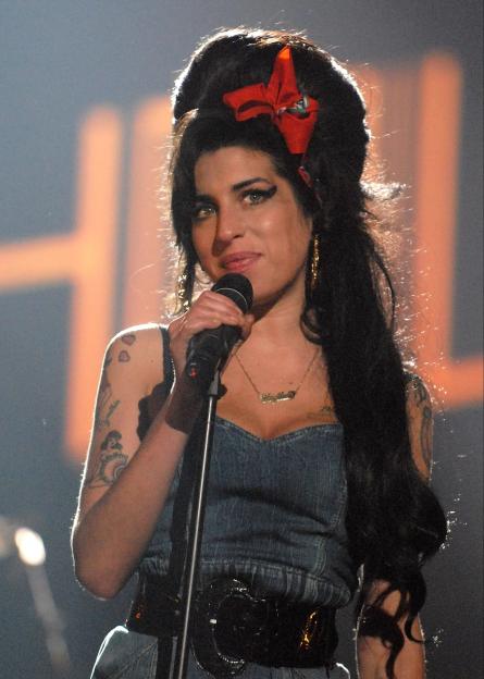 Amy Winehouse performing on stage.
