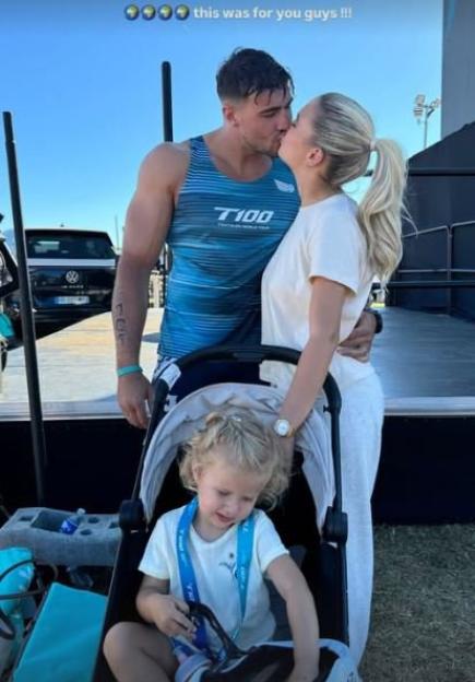 Tommy Fury and Molly-Mae Hague kissing, with their daughter in a stroller.
