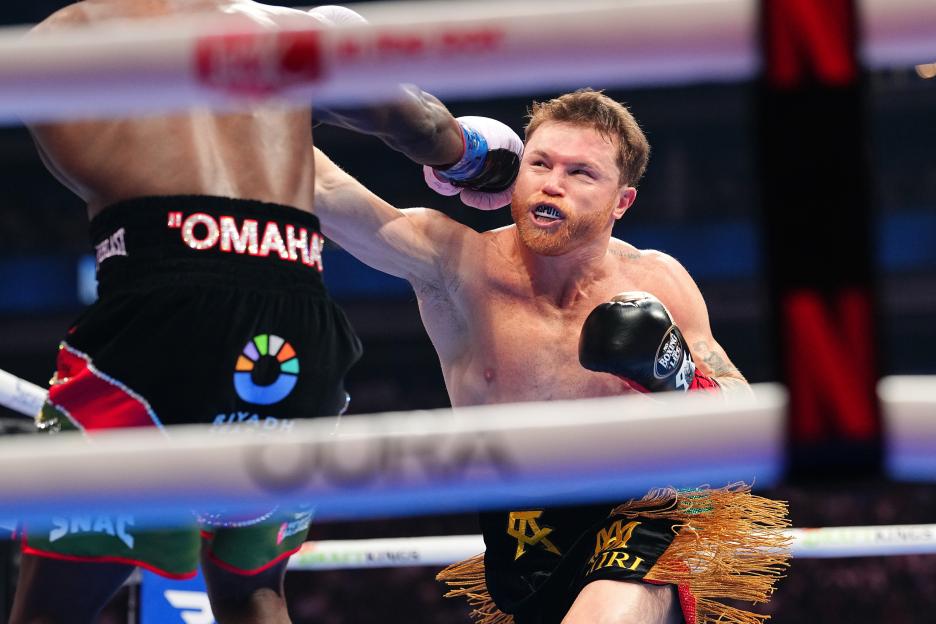 Canelo Alvarez punches Terence Crawford in a boxing match.
