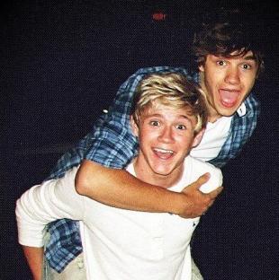Niall Horan piggybacking Liam Payne.