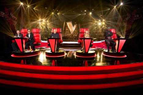 The Voice UK judges, Sir Tom Jones, LeAnn Rimes, Danny Jones and Tom Fletcher, and will.i.am, seated in their red spinning chairs on stage.