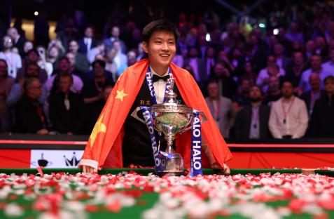 Zhao Xintong of China holding the Halo World Snooker Championship trophy.
