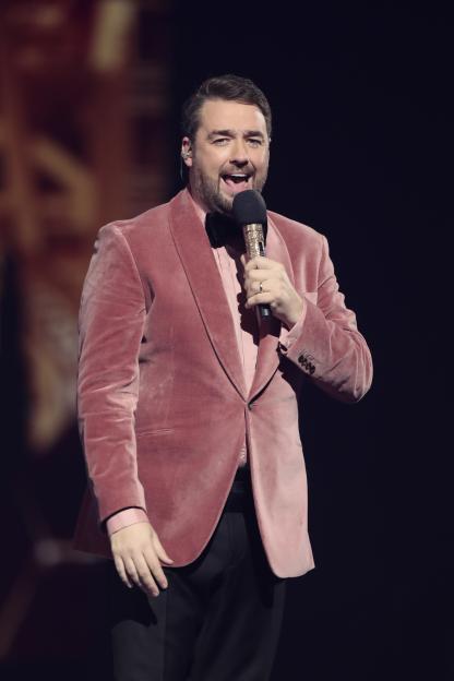 Jason Manford onstage at The National Lottery's Big Bash, holding a microphone.