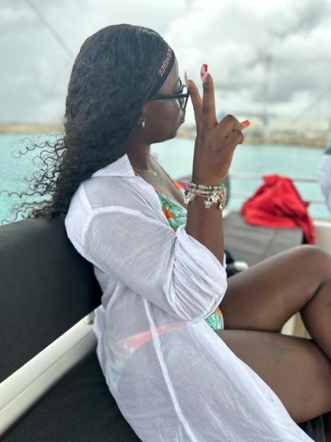 Woman on a boat making a peace sign.