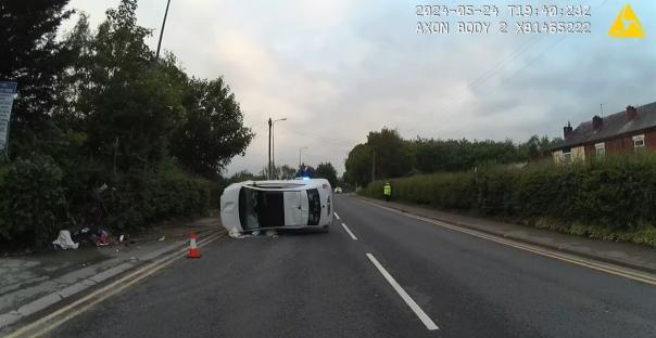 An overturned car on the side of a road.