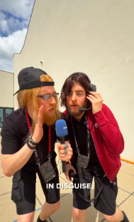 Two men in disguise holding a microphone.