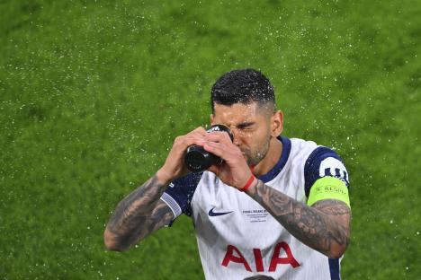 Cristian Romero of Tottenham Hotspur drinking water during a soccer match.