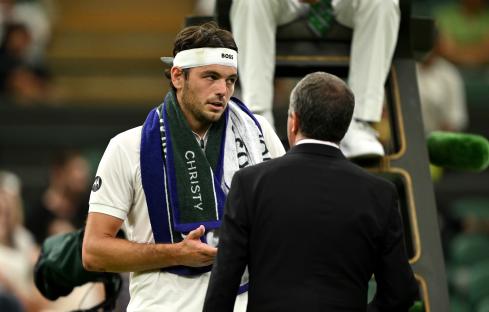 Taylor Fritz of the United States speaks with a Wimbledon official.