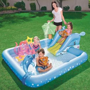 Children playing in an inflatable pool with a slide and water features.