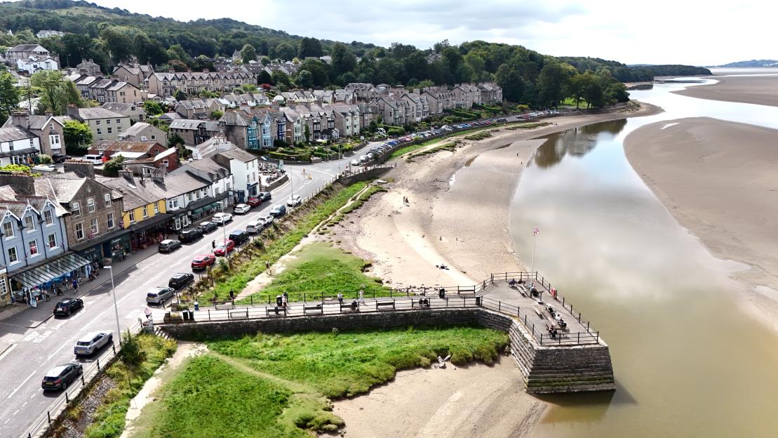 Aerial view of Arnside, Cumbria, showing the town, river, and a small pier.