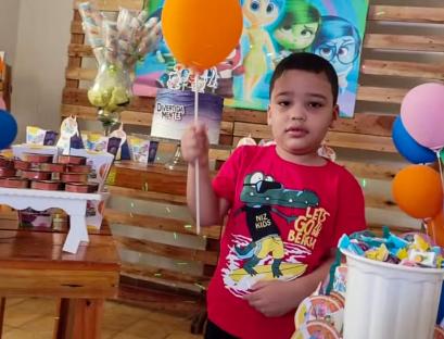 Boy at birthday party holding balloon.
