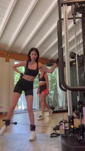 Woman doing leg exercises with ankle weights in a gym.