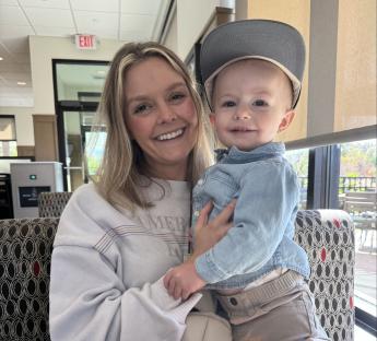 A woman and toddler sitting at a table.