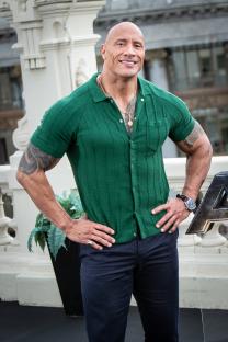 a man in a green shirt is standing with his hands on his hips