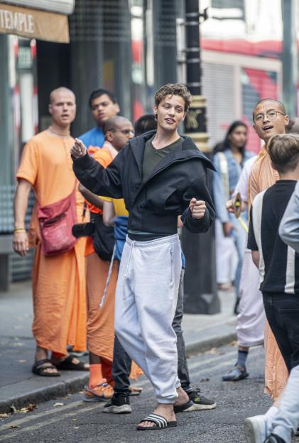 Bobby Brazier dancing and chanting with Hare Krishna devotees on Oxford Street.