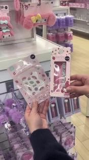 Hands holding Hello Kitty-themed beauty products and accessories.