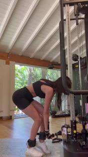 Woman attaching ankle weights to a weight machine.