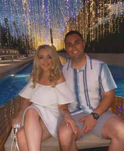 Couple posing in front of the Rixos Radamis hotel at night.