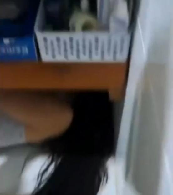 Long dark hair trailing from under a shelf.