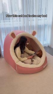 Woman and cats in a pink cat bed.