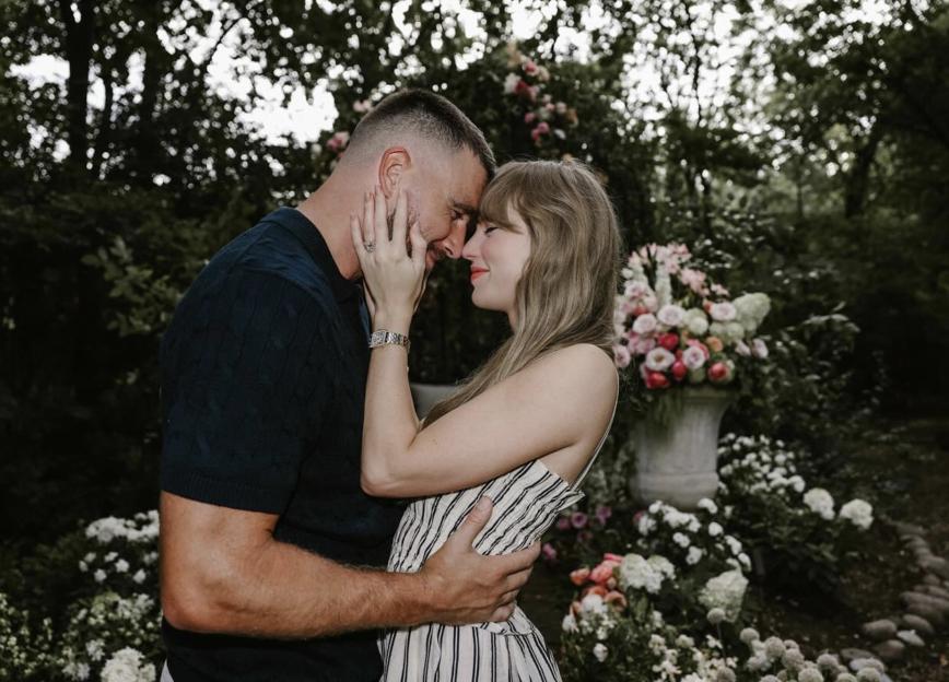 Taylor Swift and Travis Kelce embracing in a garden, with Taylor wearing a ring.