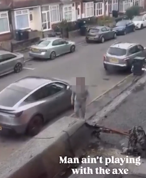 A man carrying an axe walks towards a car on a residential street.