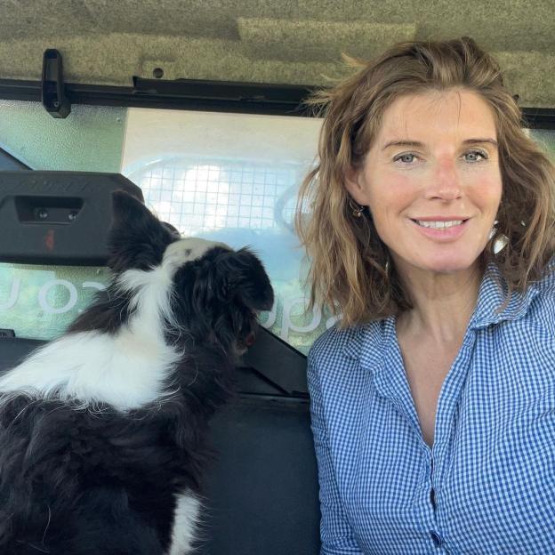Amanda Owen with her dog in a vehicle.