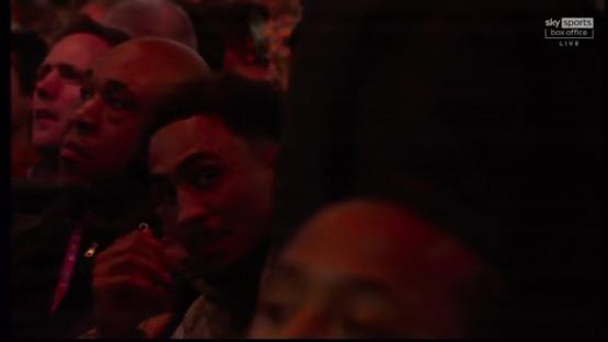 Close-up of audience members at a boxing match.