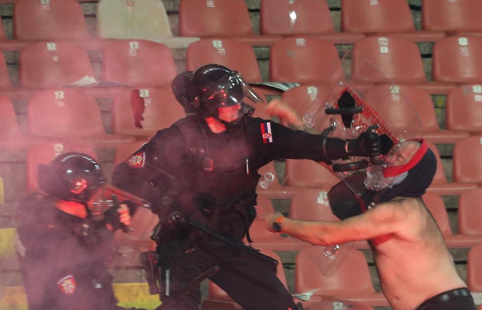 A Partizan supporter clashes with police during a soccer match in Belgrade.