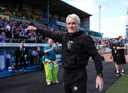 Carlisle United Head Coach Mark Hughes gesturing at a football match.