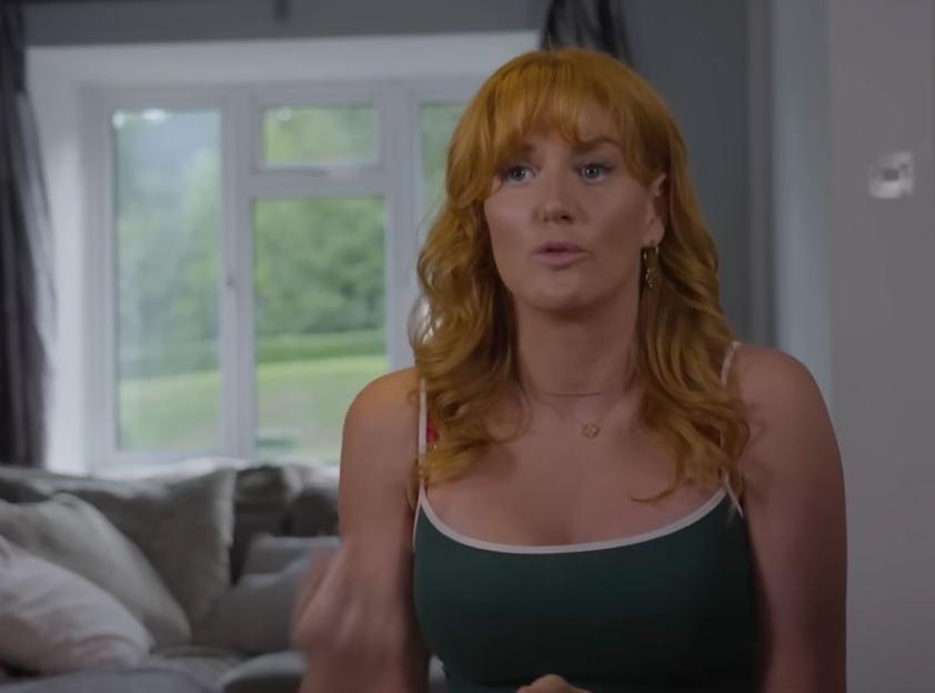 Annie, a woman with red hair and a green tank top, discusses her Uterus Didelphys condition.