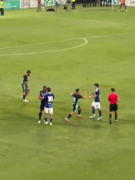 Soccer players arguing on the field.