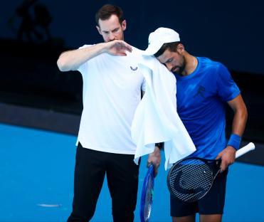 Novak Djokovic of Serbia practices tennis with his coach.
