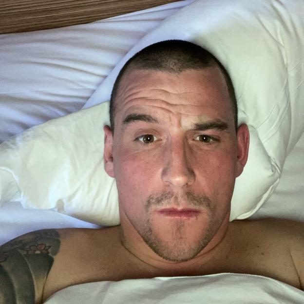 Close-up selfie of a man lying in bed.