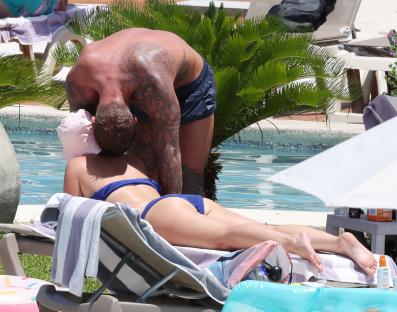 A man kissing a woman by a pool.