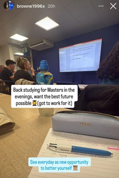 Emily Browne studying at a desk with notes, a pen, and a pencil case, while a screen displaying a presentation about Freud and Lacan is visible in the background.