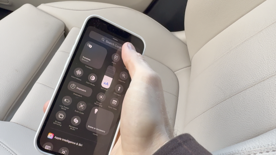 Hand holding iPhone displaying Control Center.