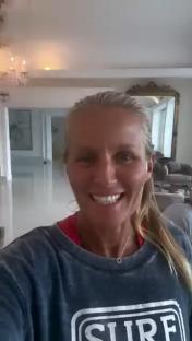 Smiling woman in a dark gray sweatshirt.
