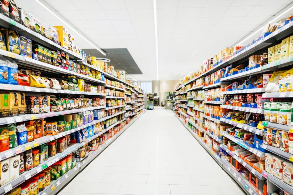 Stocked supermarket aisle with various food items.