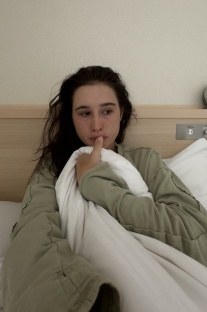 Woman in bed looking thoughtful.