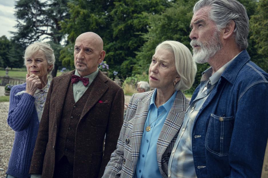 Scene from *The Thursday Murder Club* showing Celia Imrie, Ben Kingsley, Helen Mirren, and Pierce Brosnan.