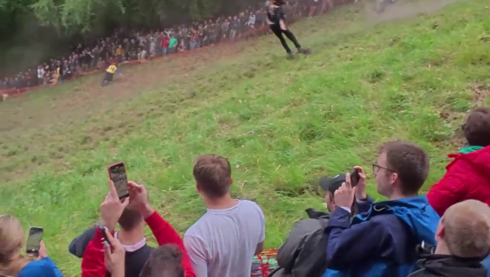 Contestant performing a somersault during a cheese rolling competition.