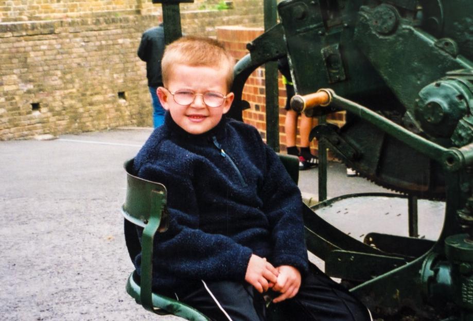 Andrew Gosden at age 5 sitting in a green metal structure.