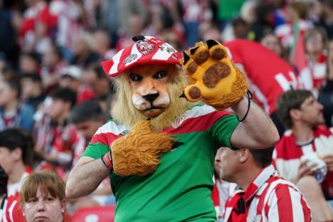 Athletic Club Bilbao fan in a lion costume at a soccer match.