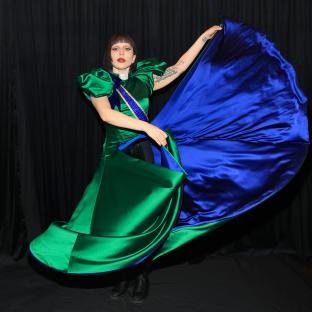 Lady Gaga in a green and blue satin gown backstage.