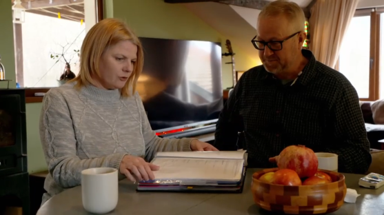 A man and woman review paperwork at a table.