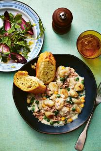Tuna gnocchi with peas and corn, served with garlic bread and a side salad.