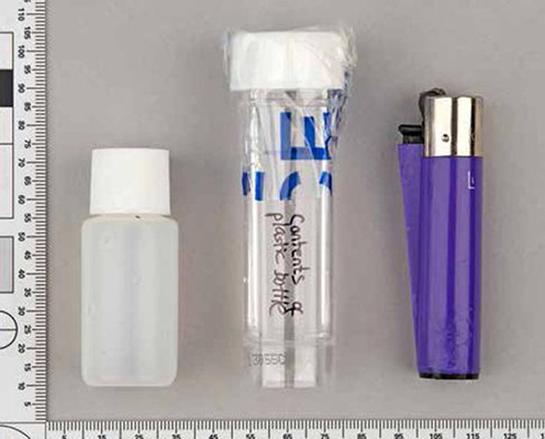 A plastic bottle containing GBL found on victim Jack Taylor, next to a smaller plastic bottle and a purple lighter.