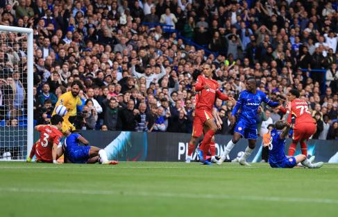 Virgil van Dijk kicking the ball, resulting in an own goal during a Chelsea FC and Liverpool FC match.